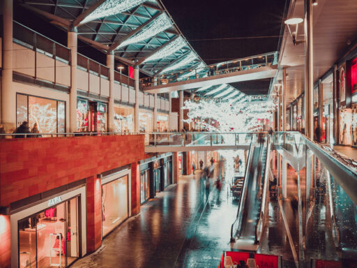 Mostly empty and dimly lit shopping centre with Christmas decorations.